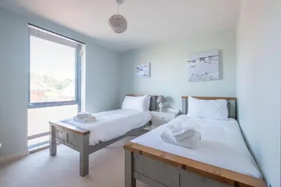 a bedroom with two beds and a window at 3 King Georges House - Aldeburgh Coastal Cottages in Aldeburgh