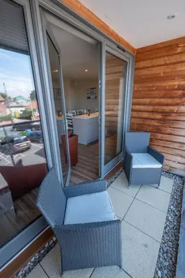 a balcony with two chairs and a table at 3 King Georges House - Aldeburgh Coastal Cottages in Aldeburgh