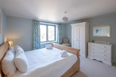 a bedroom with a large white bed and a window at 3 King Georges House - Aldeburgh Coastal Cottages in Aldeburgh