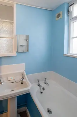 a bathroom with a white tub and a sink at Ginnys Cottage by Aldeburgh Coastal Cottages in Aldeburgh