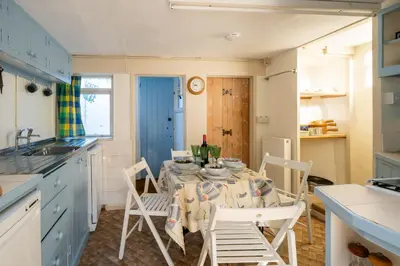 a dining room with a table and chairs in a kitchen at Ginnys Cottage by Aldeburgh Coastal Cottages in Aldeburgh