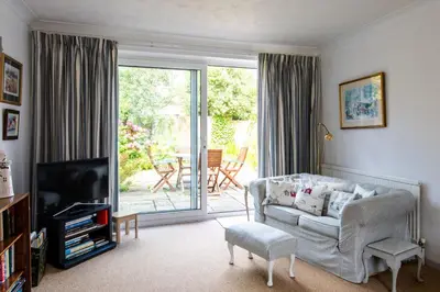 a living room with a couch and a television at 2 Admirals Walk by Aldeburgh Coastal Cottages in Thorpeness