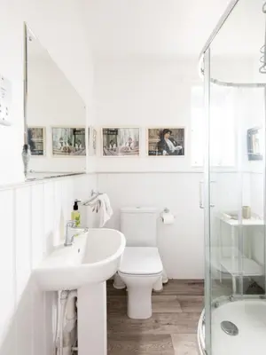 a white bathroom with a toilet and a sink at 2 Admirals Walk by Aldeburgh Coastal Cottages in Thorpeness