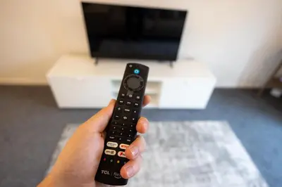 a person holding a remote control in their hand at Hampstead Avenue in Great Clacton