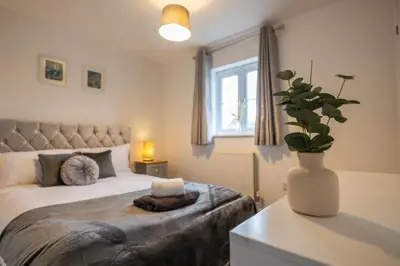 a bedroom with a bed and a vase with a plant at Hampstead Avenue in Great Clacton