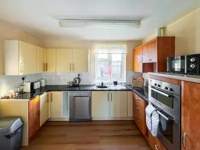 a kitchen with wooden cabinets and a stove top oven at Lowal House - Uk46054 in Saffron Walden