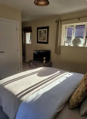 a bedroom with a large white bed with a window at Beautiful garden room in Red Lodge