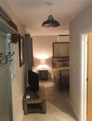 a room with a bedroom with a bed and a television at Beautiful garden room in Red Lodge