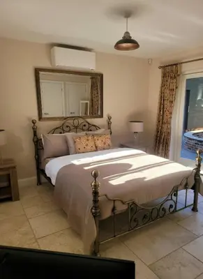 a bedroom with a large bed and a mirror at Beautiful garden room in Red Lodge
