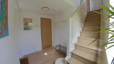 a staircase in a home with white walls and wooden floors at Fully Refurbished 3 bed Victorian Cottage in Tolleshunt D'Arcy in Tolleshunt DʼArcy