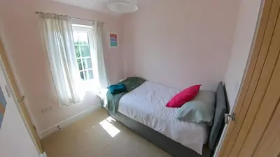 a small bedroom with a bed and a window at Fully Refurbished 3 bed Victorian Cottage in Tolleshunt D'Arcy in Tolleshunt DʼArcy
