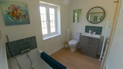 a bathroom with a sink and a toilet and a mirror at Fully Refurbished 3 bed Victorian Cottage in Tolleshunt D'Arcy in Tolleshunt DʼArcy