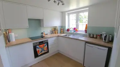 a kitchen with white cabinets and a sink at Fully Refurbished 3 bed Victorian Cottage in Tolleshunt D'Arcy in Tolleshunt DʼArcy
