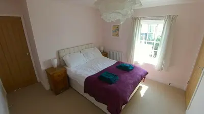 a bedroom with a bed with two green towels on it at Fully Refurbished 3 bed Victorian Cottage in Tolleshunt D'Arcy in Tolleshunt DʼArcy