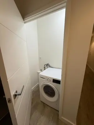 a small bathroom with a washing machine in it at Prestige 1 bed apartment in Shenfield