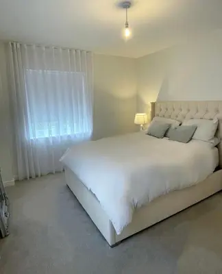 a bedroom with a large white bed and a window at Prestige 1 bed apartment in Shenfield