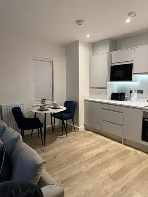 a kitchen and living room with a couch and a table at Prestige 1 bed apartment in Shenfield
