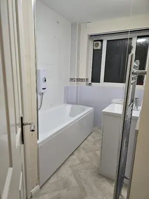 a white bathroom with a tub and a sink at Barnfield Rooms in Chelmsford