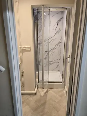 a shower with a glass door in a bathroom at Barnfield Rooms in Chelmsford