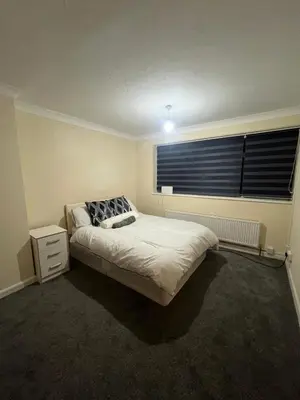 a bedroom with a bed and a window at Barnfield Rooms in Chelmsford