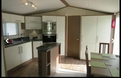 a kitchen with white cabinets and a black counter top at Weeley Bridge 3 Bedroom Luxury Holiday Home in Weeley