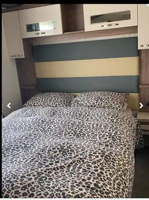 a bedroom with a bed with a cheetah print blanket at Weeley Bridge 3 Bedroom Luxury Holiday Home in Weeley