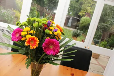 a vase filled with colorful flowers sitting on a table at Gidea Park Hotel in Romford