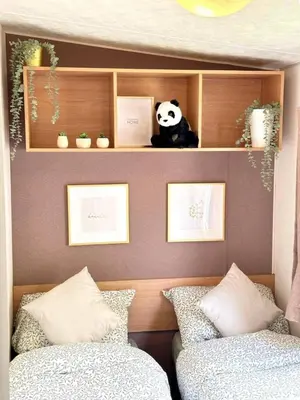 a bedroom with two beds and a stuffed panda bear on a shelf at Harwich - Caravan - Sleeps 10 - Garden - Pool in Harwich