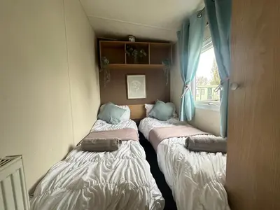 three beds in a room with a window at Harwich - Caravan - Sleeps 10 - Garden - Pool in Harwich