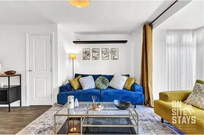 a living room with a blue couch at OnSiteStays - 4 Large Bedrooms 3 Bathrooms 1 WC Parking Garden & Wifi in Basildon