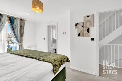 a white bedroom with a bed and a window at OnSiteStays - 4 Large Bedrooms 3 Bathrooms 1 WC Parking Garden & Wifi in Basildon