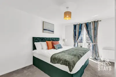 a bedroom with a large bed and a window at OnSiteStays - 4 Large Bedrooms 3 Bathrooms 1 WC Parking Garden & Wifi in Basildon