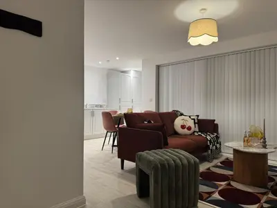 a living room with a couch and a table at Modern & Elegant with Free Parking & Balcony in Cambourne