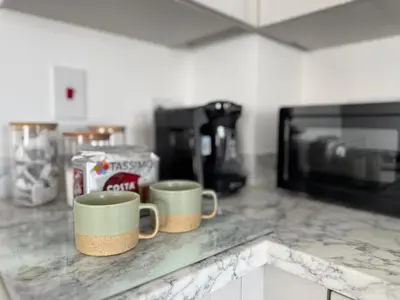 two coffee mugs sitting on a counter in a kitchen at Modern & Elegant with Free Parking & Balcony in Cambourne
