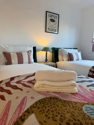 a bedroom with two beds with towels on the floor at Modern & Elegant with Free Parking & Balcony in Cambourne