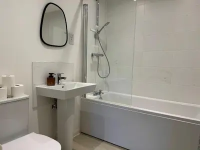 a bathroom with a shower and a sink and a bath tub at Modern & Elegant with Free Parking & Balcony in Cambourne