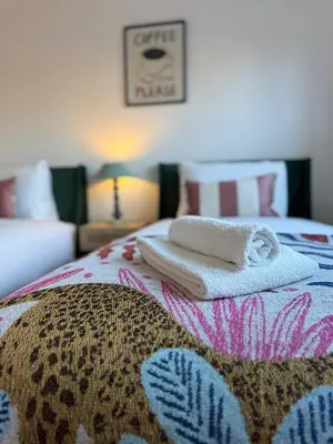 a bed with two towels sitting on top of it at Modern & Elegant with Free Parking & Balcony in Cambourne
