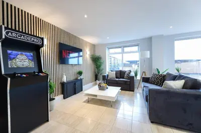a living room with a television and a living room with a couch at Penthouse with Hot Tub by Cambridge Station in Cambridge