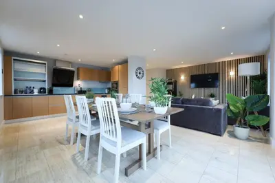 a kitchen and living room with a table and chairs at Penthouse with Hot Tub by Cambridge Station in Cambridge
