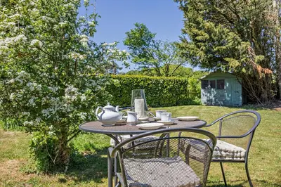 a table with a tea set on it in a yard at 1 Bed in Hundon oc-t30616 in Hundon