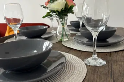 a wooden table with plates and glasses of wine at Central Chelmsford 2-Bed Apt 5 mins to Station in Chelmsford