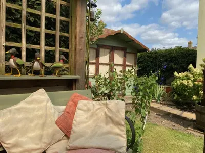 a green bench with a pillow and some birds on a window at 3 Bed in Hingham oc-m29945 in Hingham