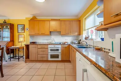 a kitchen with wooden cabinets and a large window at 3 Bed in Hingham oc-m29945 in Hingham