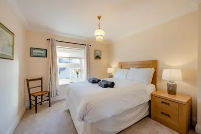 a bedroom with a large white bed and a chair at 3 Bed in Hingham oc-m29945 in Hingham