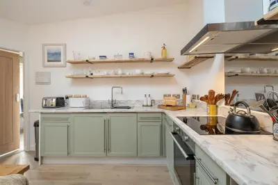 a kitchen with green cabinets and a sink at Hale House, Leiston - Aldeburgh Coastal Cottages in Leiston
