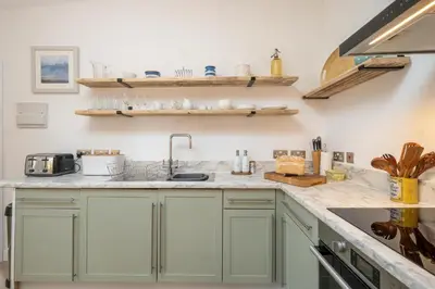 a kitchen with green cabinets and a sink at Hale House, Leiston - Aldeburgh Coastal Cottages in Leiston