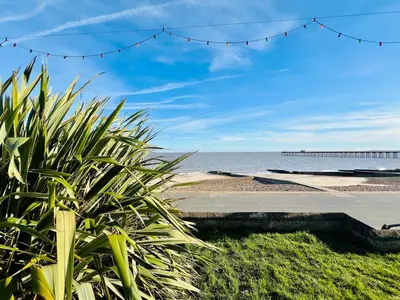 a view of the beach with a pier in the background at 4-Bedroom House 5 mins to Beach & Parking in Felixstowe