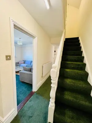 a staircase in a house with a green carpet at 4-Bedroom House 5 mins to Beach & Parking in Felixstowe
