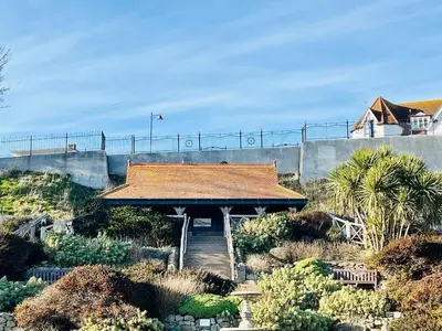 a building with a roof on top of a garden at 4-Bedroom House 5 mins to Beach & Parking in Felixstowe