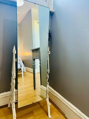 a mirror on a stand in a room at 4-Bedroom House 5 mins to Beach & Parking in Felixstowe